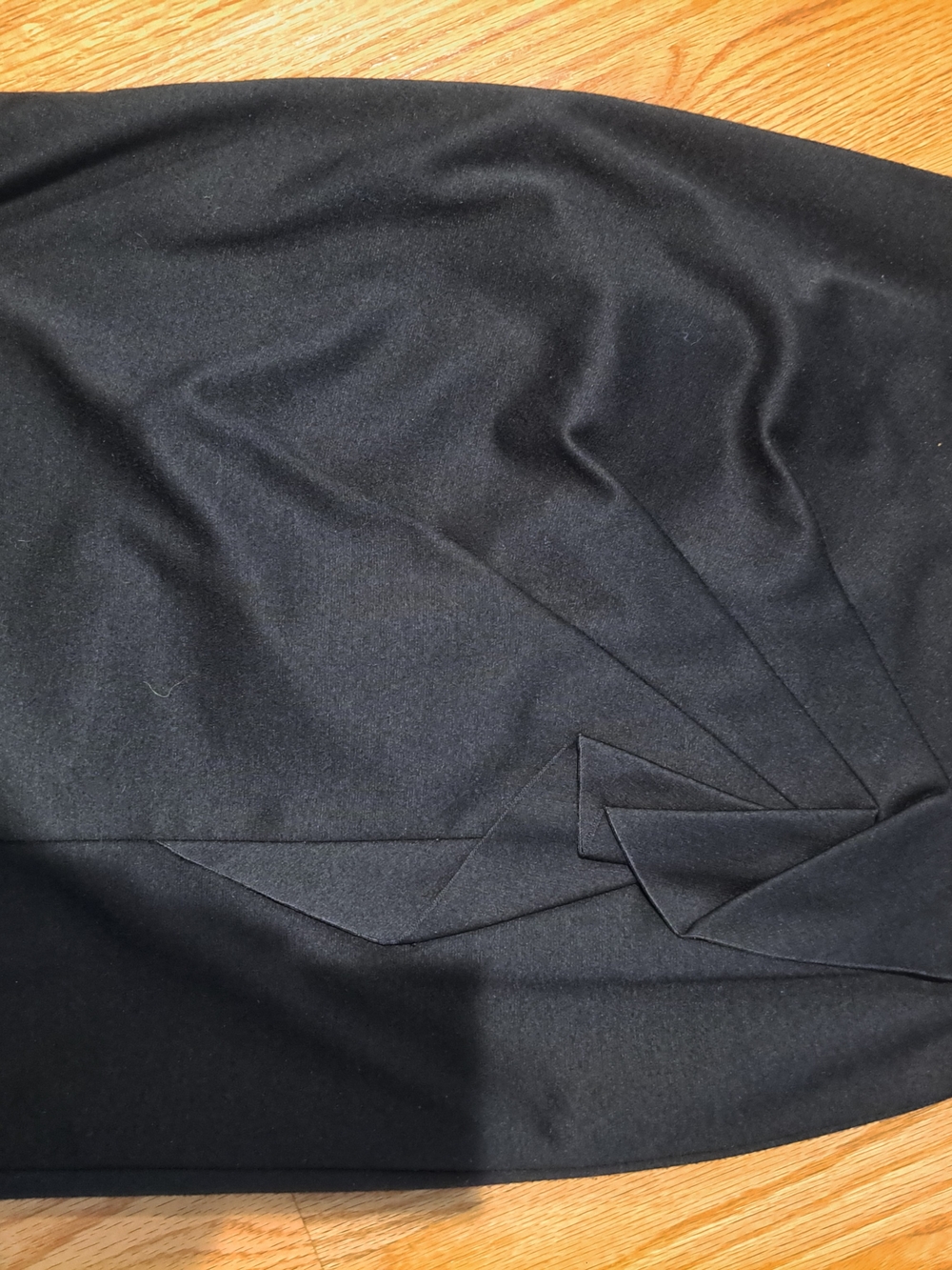 Elegant black Tahari pencil skirt is a size 6. It has an origami-style pleated d